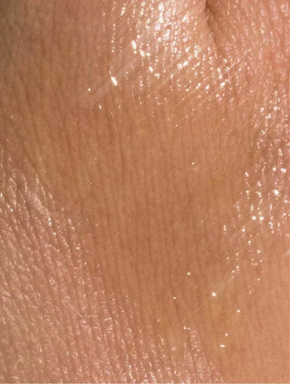 Close-up of glowing skin with applied Organic Facial Oil, showcasing deep hydration and radiance.